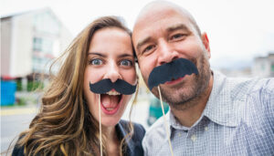 Participants s'amusent avec de fausses moustaches pendant un team building à Paris sur le thème des Jeux Olympiques Paris 2024